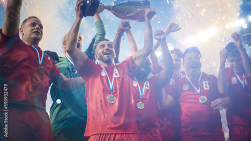 Football Finals Tournament Winning Team Celebrates Victory Cheering and Lifting Trophy Prize, Showing it to the Whole Stadium Arena. Happy Soccer Players, Champions of International Championship Cup