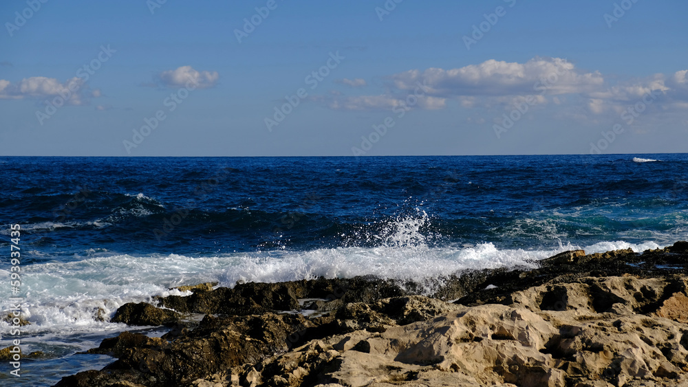 Blue sea wave and white foam and splash. Stone beach on island of Malta, no sandy beach. Summer holiday border frame concept. Tropical island vacation backdrop. Tourist travel banner design template. Blue sea wave and white foam and splash. Stone beach on island of Malta, no sandy beach. Summer holiday border frame concept. Tropical island vacation backdrop. Tourist travel banner design template.