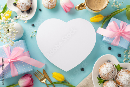 Happy mother's day trendy celebration concept. Top view flat lay of cupcakes, presents, coffee, tulips on pastel blue background. Blank heart for text or greeting