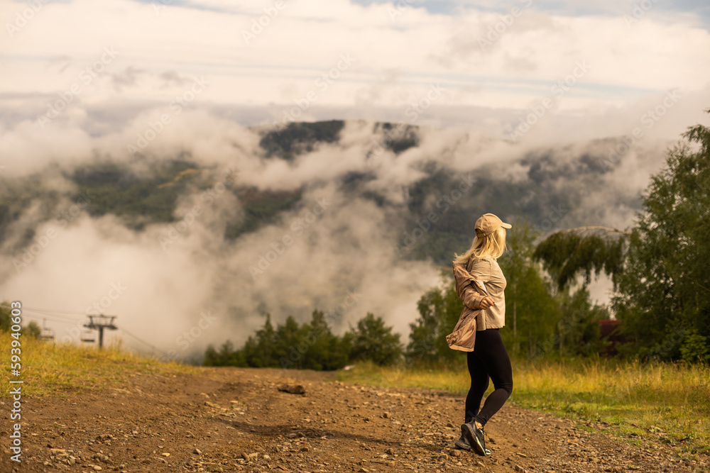 a woman rests after a hike in the mountains a woman rests after a hike in the mountains