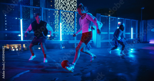 Empowering Sporty Young Woman Playing Soccer with Friends, Dribbling, Scoring a Successful Goal. Female Footballer Playing Football Outside at Night on Rooftop Urban City Spot with Neon Lights