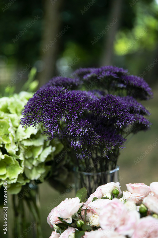 Frame image of a several bouquets of flowers arranged in vases placed on the table outside in the garden. Frame image of a several bouquets of flowers arranged in vases placed on the table outside in the garden.