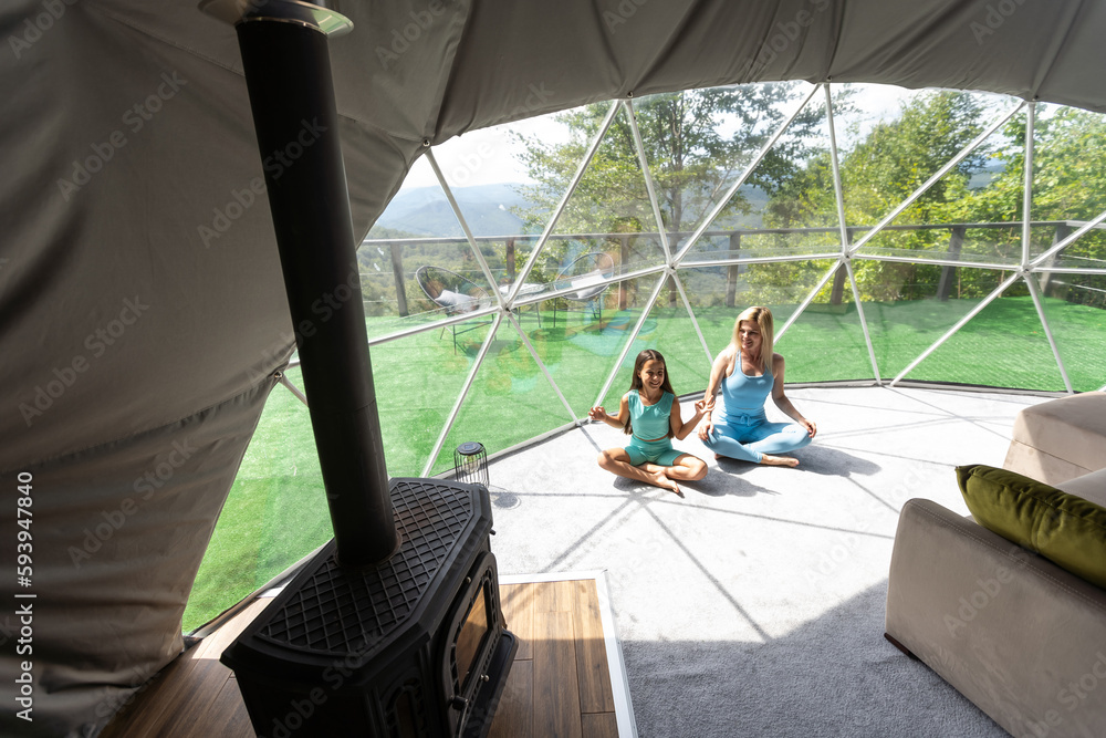mother and daughter yoga in a glamping dome tent