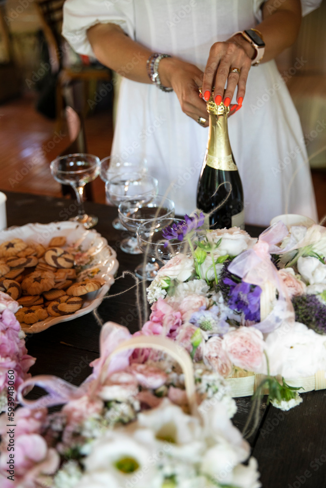 Frame image of a female hands open a bottle of sparkling wine at a party