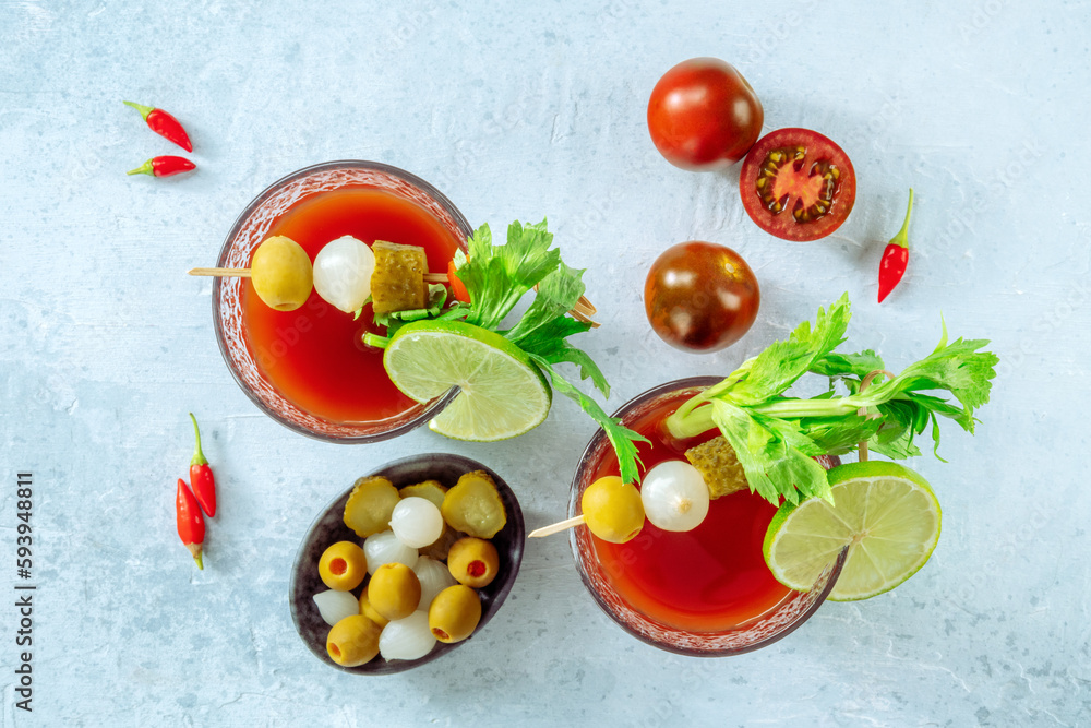 Bloody Mary cocktail with garnish, overhead flat lay shot. Spicy tomato juice with alcohol, lime, pickles, celery, and peppers Bloody Mary cocktail with garnish, overhead flat lay shot. Spicy tomato juice with alcohol, lime, pickles, celery, and peppers