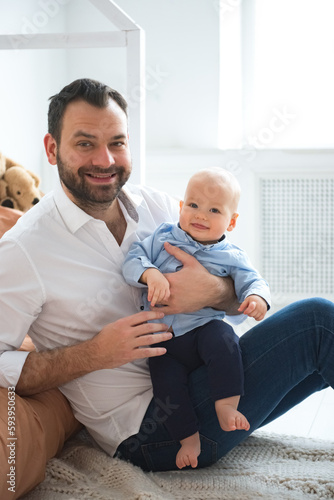 Young father with his cute little baby son, indoor portrait