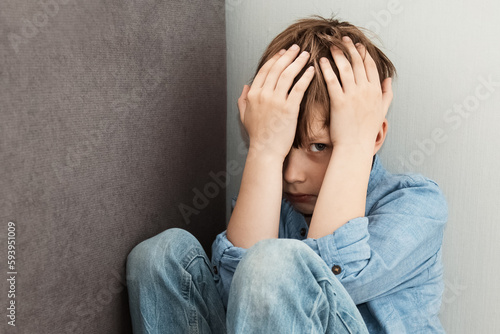 Scared little boy sitting at corner of room feeling sad and lonely. Child loneliness, Autism awareness, traumatic. The Problem of Child Development, sadness and fearful