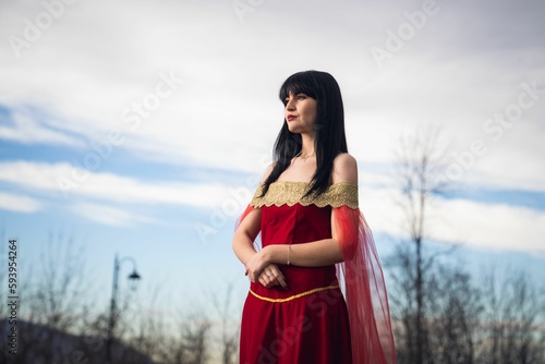 Woman wearing a medieval red dress posing outdoors