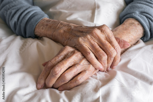 Hands of an old women close up on a bed in a hospital. Aging process, elderly women