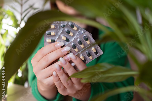 a girl sits and holds in her hands a lot of pills close-up with medicines in her hands, The concept of health care, Many drugs, chlorophyll in tablets, vitamins in tablets, healthy lifestyle