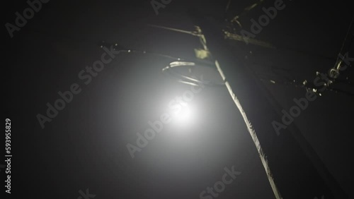 Low angle of electricity pole with moonlight in the night sky in Port Alberni, Canada photo
