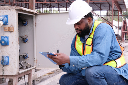 Engineer checking electrical control cabinet.