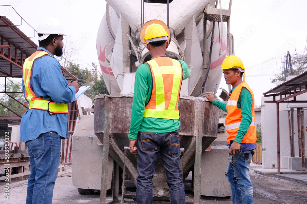 Workers and cement mixer at construction site. Workers and cement mixer at construction site.