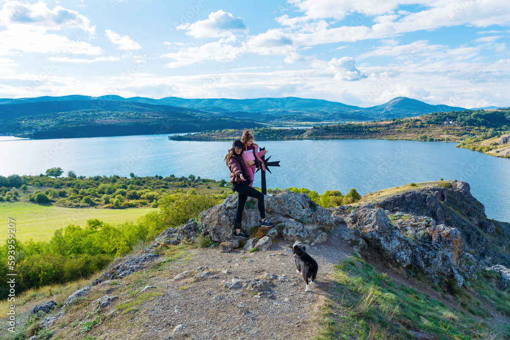 Woman ,Kid and Dog Traveling  in the Mountain on a Lake Background  .Family Portrait in the Nature 