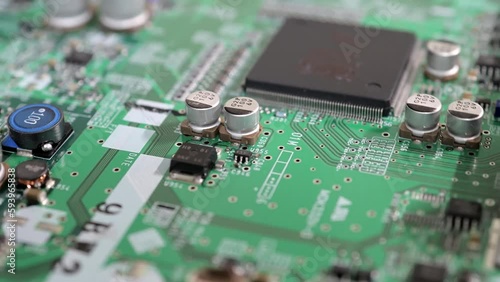 April 2023 in Tokyo, Japan. Extreme close-up of a printed circuit board with rotating electronic components and microchips.