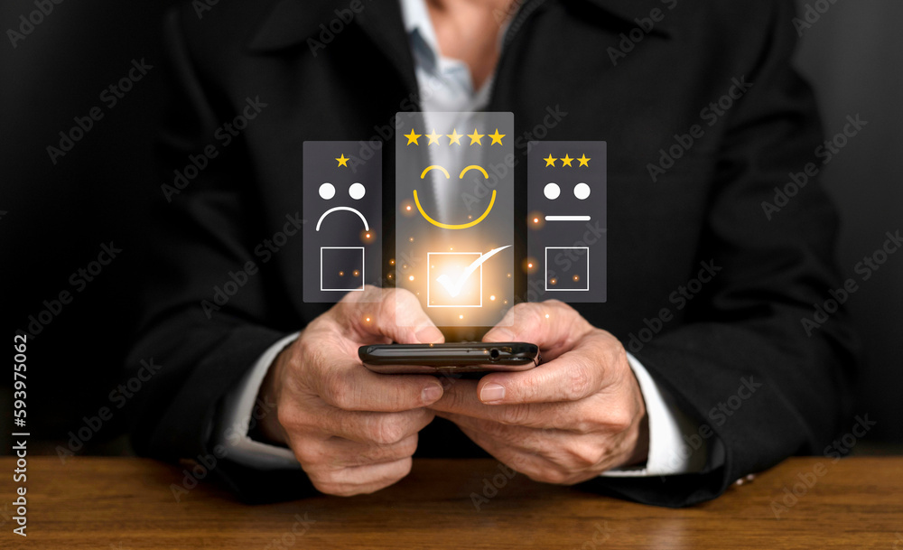 Businessman pressed the smile face emoticon on the virtual touch screen and give five star symbol to increase rating of products and services concept, Customer service and  satisfaction survey.