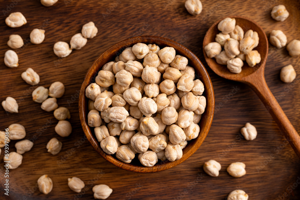 Chick pea uncooked beens. Studio shoot on wooden background. Beans spread on rustic scene.Up view shoot. Chick pea uncooked beens. Studio shoot on wooden background. Beans spread on rustic scene.Up view shoot.