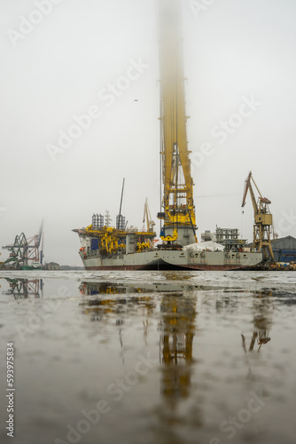 Ogromny statek z dźwigiem do montażu instalacji wiatrowych na morzu. Mglisty pochmurny dzień.  photo