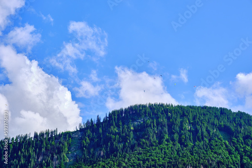 Paragliders are circling over a mountaintop. photo