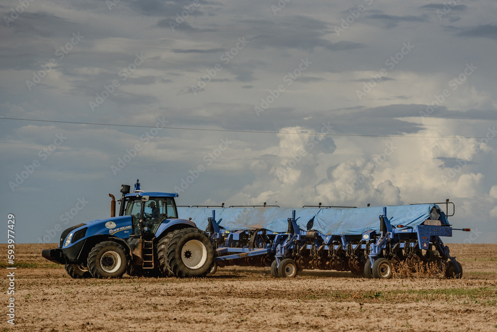 Fototapeta premium tractor in a field and clouded sky 