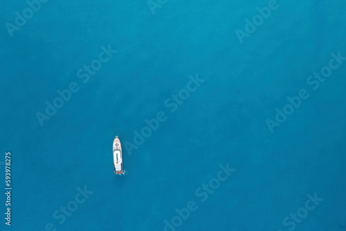Formentera. Drohnenaufnahme eines weißen Boots auf blauem Ozean.