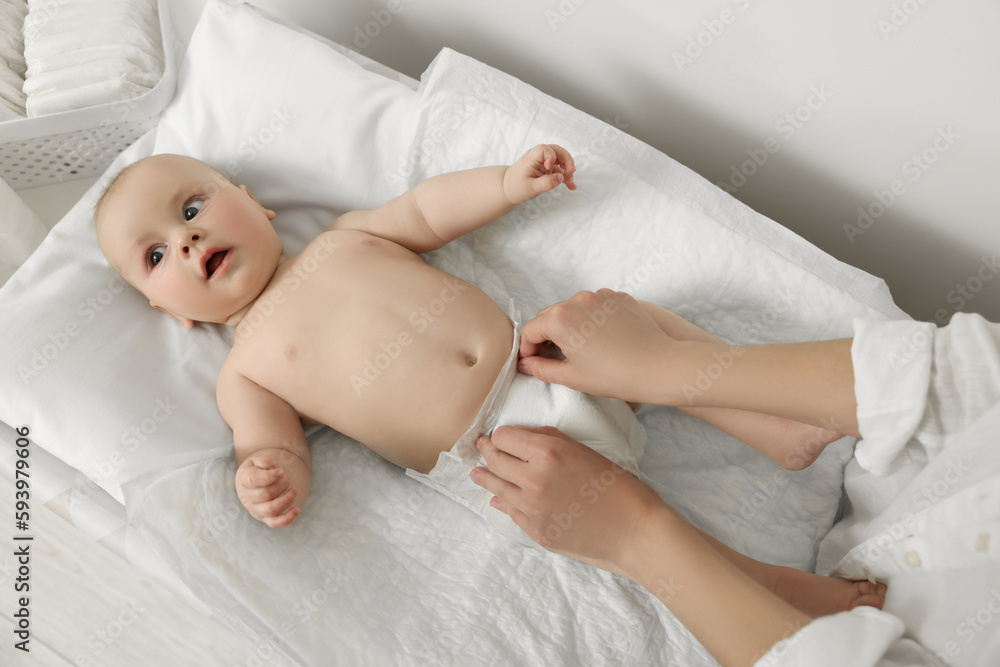 Mother changing her baby's diaper on table, closeup Mother changing her baby's diaper on table, closeup