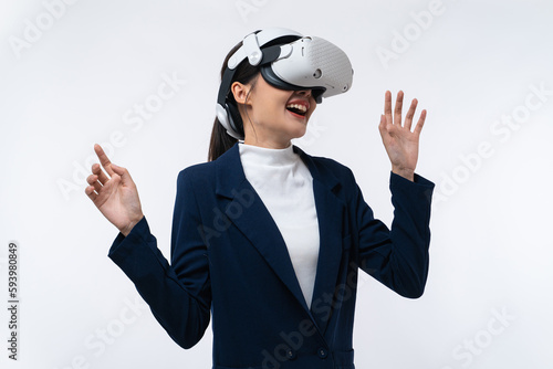 Happy young Asian businesswoman working in virtual reality environment in VR glasses touching virtual interface isolated on white background. © Jirus
