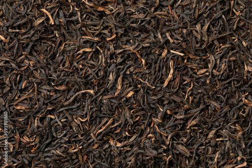 Indian Assam black Harmutty dried tea leaves full frame close up as background