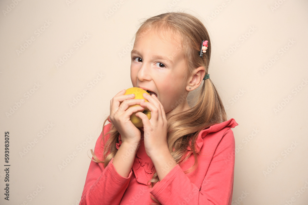 Cute little girl eating apple on light background Cute little girl eating apple on light background