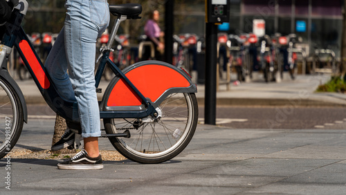 A Woman riding a rentable public bike in London