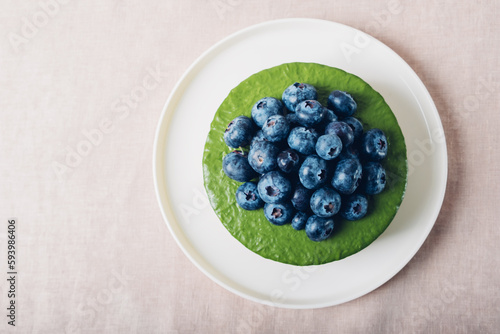 Ice cream matcha cheesecake with fresh blueberries, top view. Gluten free no bake dessert with negative space for text. Healthy sweet food.