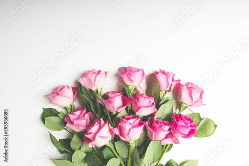 Heap of beautiful fresh pink roses in full bloom on white background. Bouquet of flowers, flat lay. Valentine's day or Mother's day card.