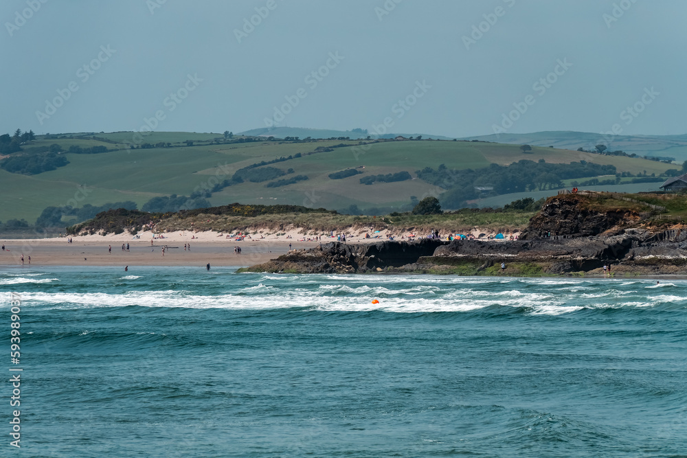Irish are relaxing on the seashore near Clonakilty, summer. Inchydoney beach, seascape. People on beach