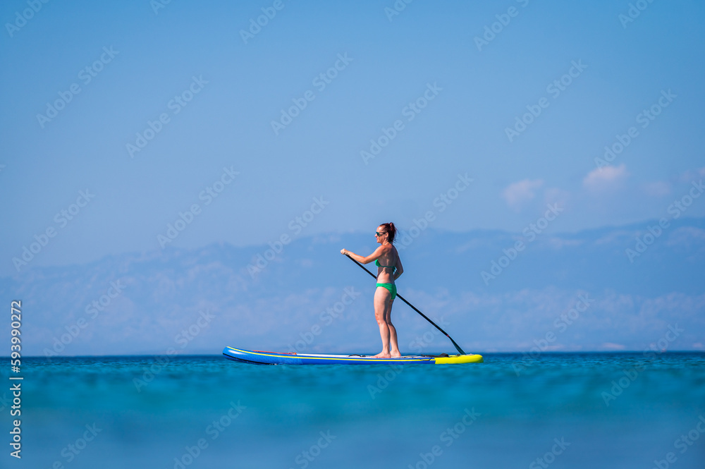 Woman riding SUP stand up paddle on vacation. Woman riding SUP stand up paddle on vacation.