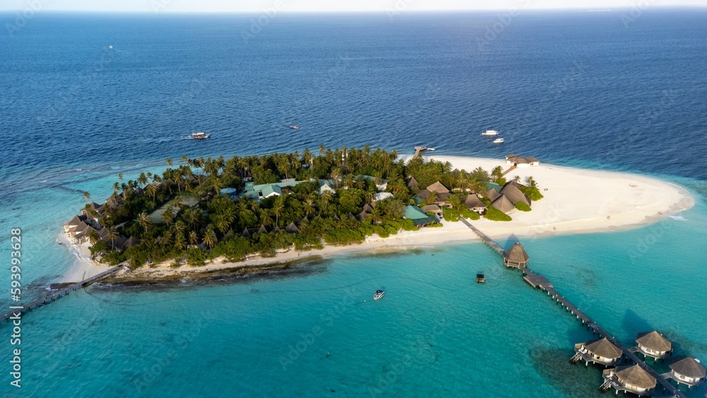Scenic aerial view of an island surrounded by tranquil blue ocean in Maldives