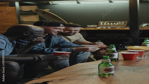 Wallpaper Mural Vertical medium full shot of three multiracial male friends hanging out in living room, making faces and smiling for selfie, drinking beer. Living room Torontodigital.ca