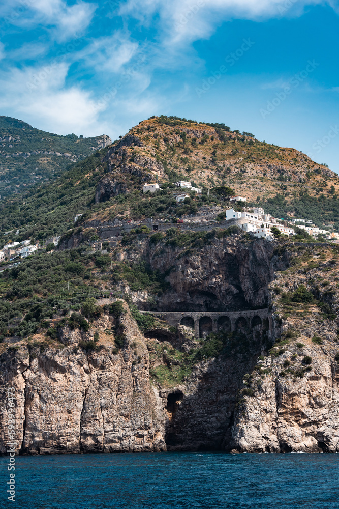 View of the side of a mountain with a road running on a bridge along its side