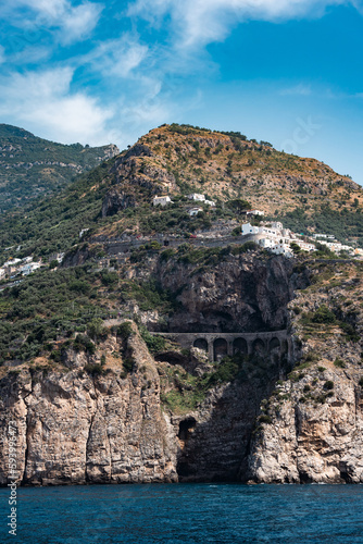 View of the side of a mountain with a road running on a bridge along its side
