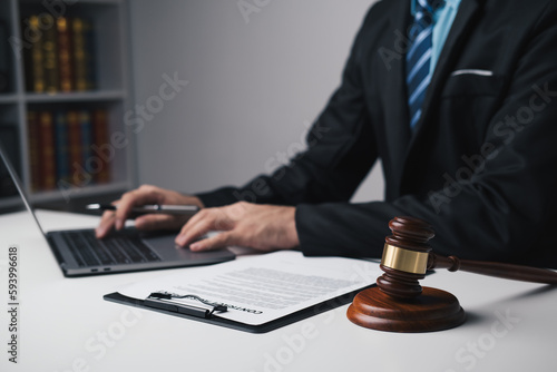 Close up view of lawyer working on his laptop computer, working for his client in the office room.