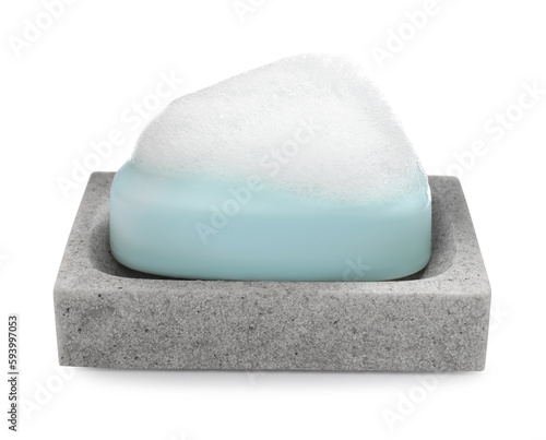 Soap bar with fluffy foam in holder on white background