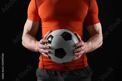 Athletic man with soccer ball on black background, closeup © New Africa