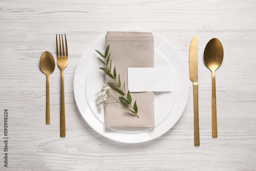 Stylish setting with cutlery, eucalyptus leaves and blank card on white wooden table, flat lay. Space for text - obrazy, fototapety, plakaty 