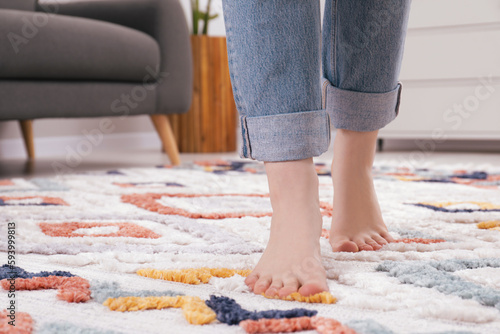 Woman standing on soft carpet at home, closeup