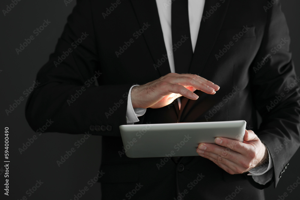 Closeup view of businessman using new tablet on black background Closeup view of businessman using new tablet on black background