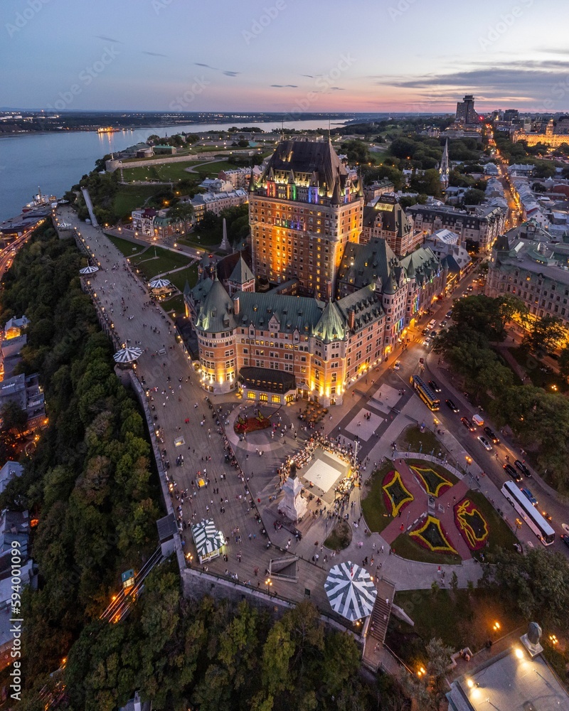 Fototapeta premium Chateau Frontenac in Quebec City lit up at sunset with people walking around