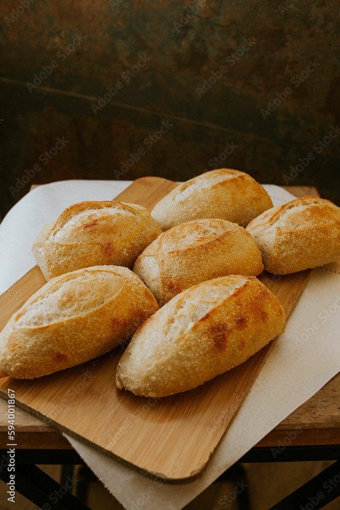 Close-up shot of freshly-baked bread resting on a wooden cutting board