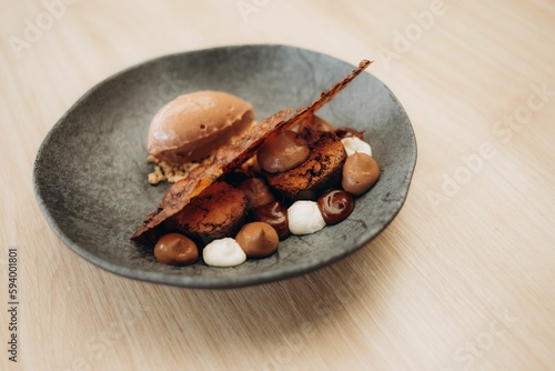 some kind of dessert on a black plate on a wood table