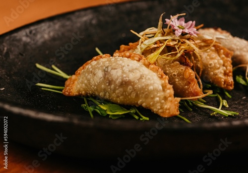 A closeup shot of a black plate with fried dish