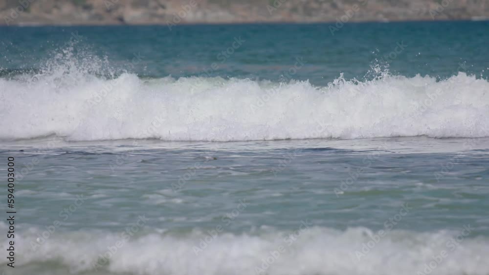 Closeup video of sea waves crashing on the beach on a sunny day Closeup video of sea waves crashing on the beach on a sunny day
