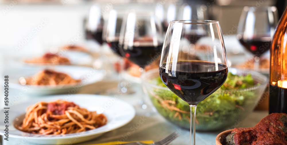 Table set for lunch with genuine products of Italian cuisine like tasty spaghetti with tomato sauce and amazing red wine - Concept of presentation of genuine Italian food famous in the world Table set for lunch with genuine products of Italian cuisine like tasty spaghetti with tomato sauce and amazing red wine - Concept of presentation of genuine Italian food famous in the world